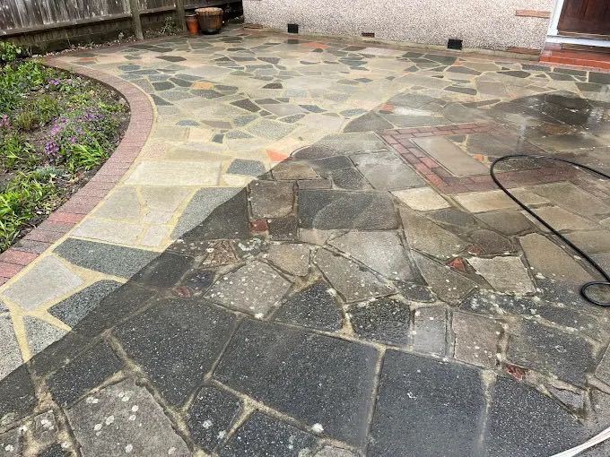 Crazy paving patio half cleaned, showing the contrast between washed and unwashed stone